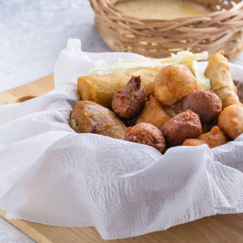 istockphoto-2086745200-612x612 Nigerian canape - small chops with spring-rolls, samosa, puff-puff in a basket covered with paper